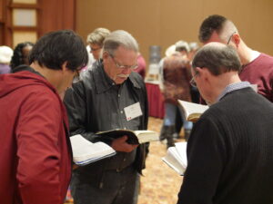 Men praying from the scriptures at the Northern California Prayer Summit
