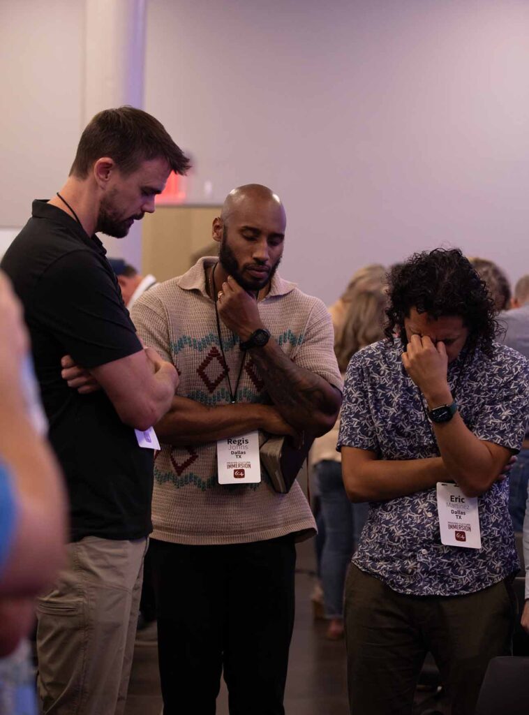 There gentleman praying in a group at a prayer meeting
