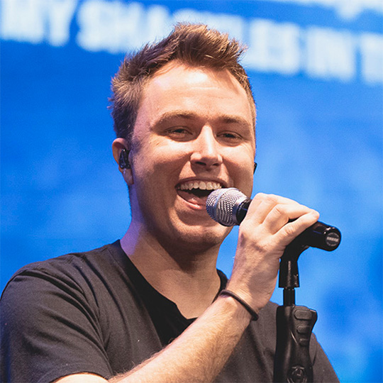 Travis Doucette singing into a microphone