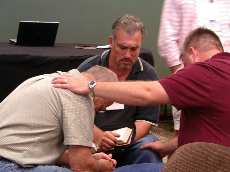 three pastors praying together