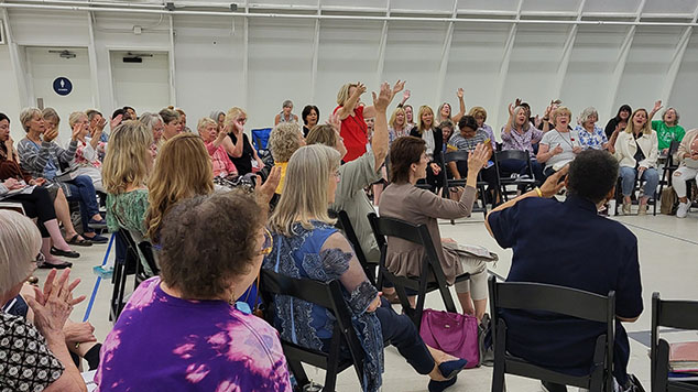 room full of women worshipping God at a prayer summit